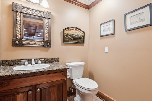 half bathroom with crown molding, toilet, vanity, and baseboards