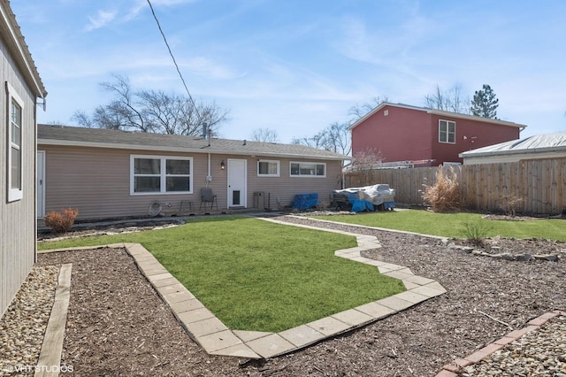 back of house featuring a yard and fence