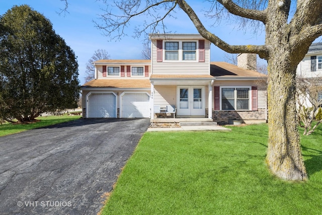 view of front of home featuring driveway, a chimney, a front lawn, and french doors