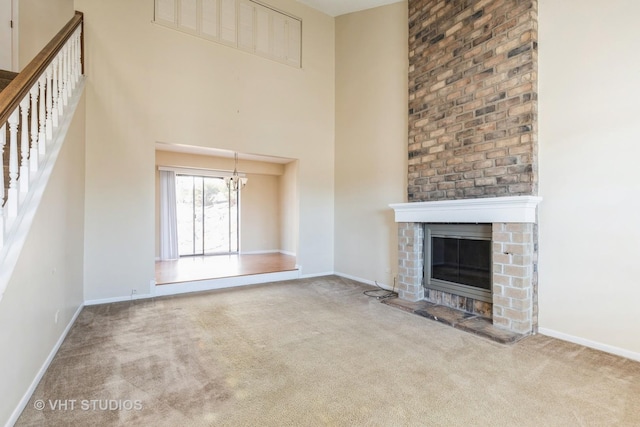 unfurnished living room with carpet, a fireplace, and baseboards