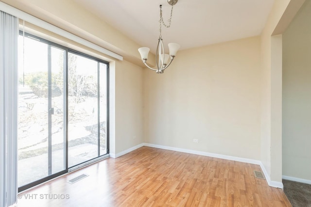 empty room with baseboards, visible vents, and light wood finished floors