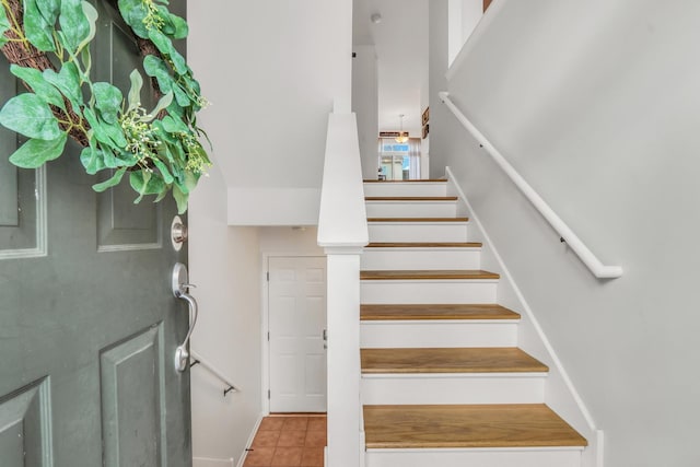 staircase with baseboards and tile patterned floors