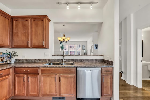 kitchen featuring dishwasher, brown cabinetry, dark countertops, and a sink