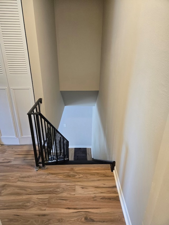 stairway featuring wood finished floors and baseboards