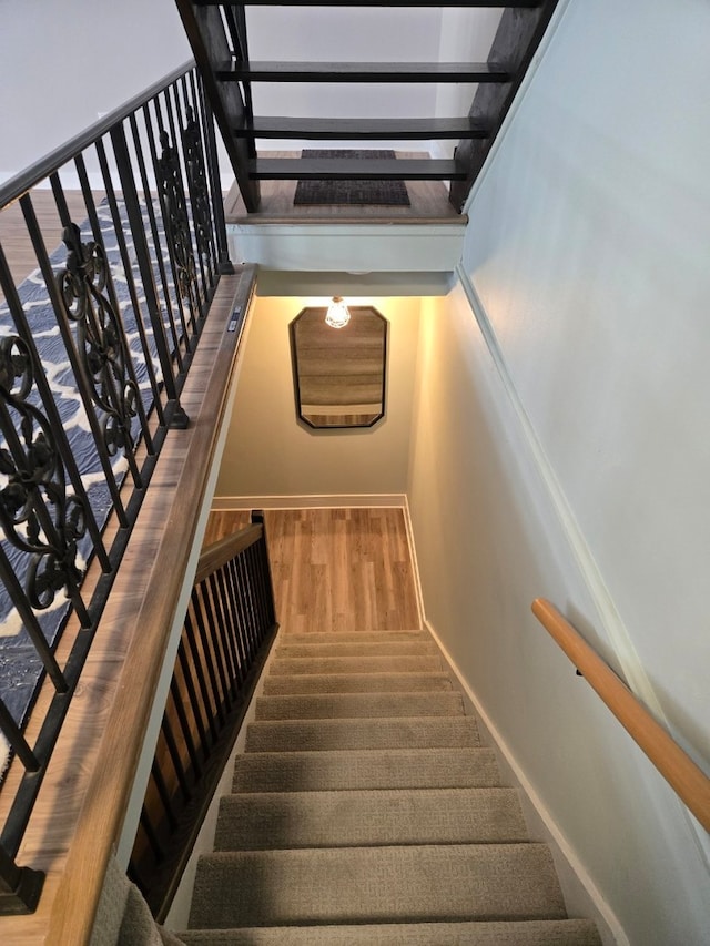 staircase with baseboards and wood finished floors