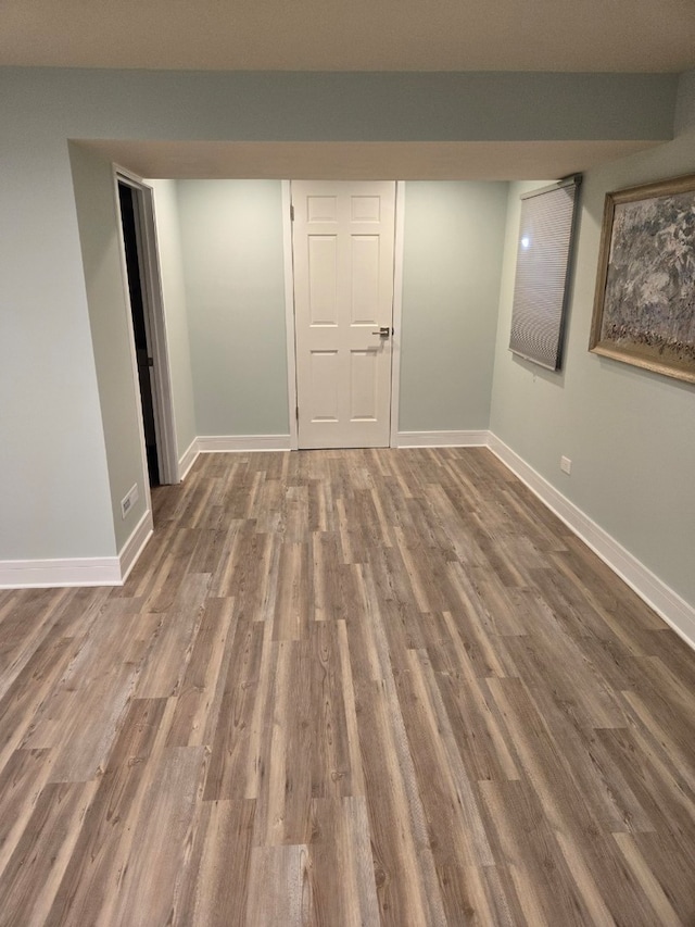 empty room with baseboards and wood finished floors