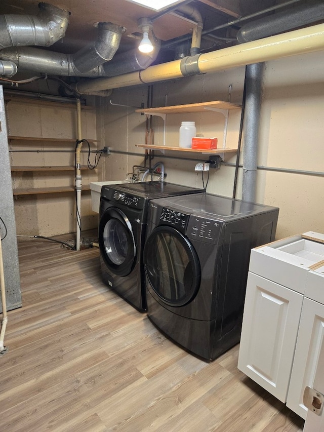 laundry area with laundry area, light wood finished floors, and separate washer and dryer