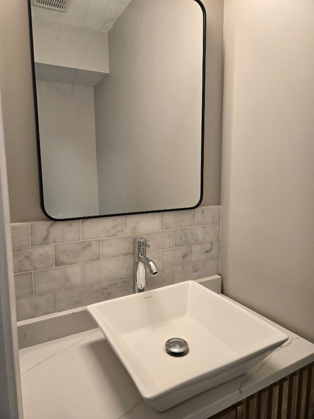 bathroom featuring tasteful backsplash and a sink