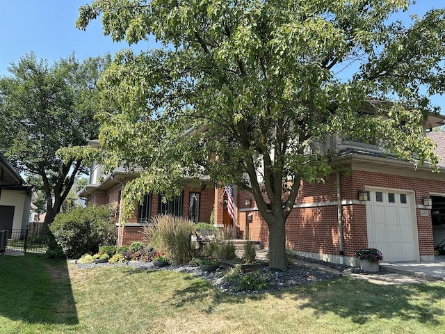 view of property hidden behind natural elements featuring an attached garage, a front yard, and brick siding