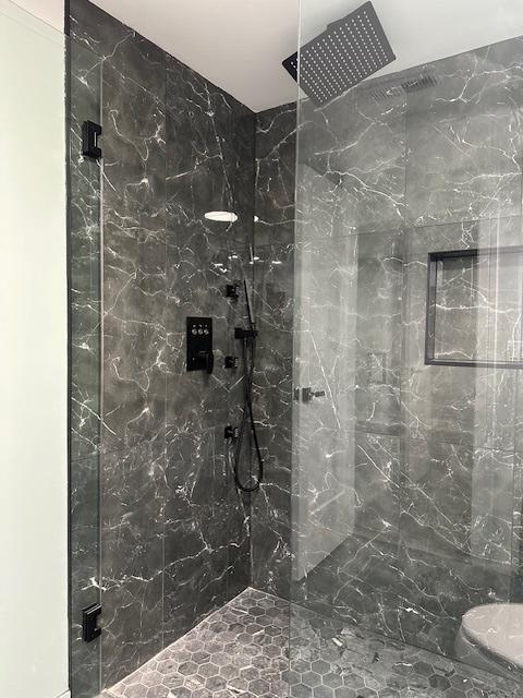 bathroom with a marble finish shower