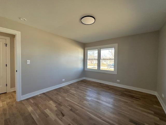 empty room featuring baseboards and wood finished floors