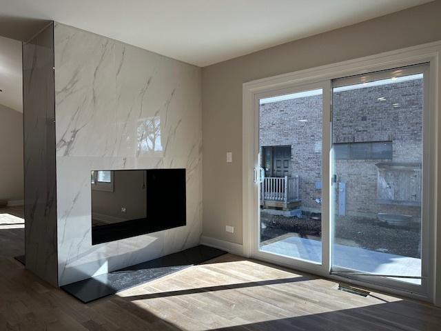 unfurnished living room with baseboards and wood finished floors