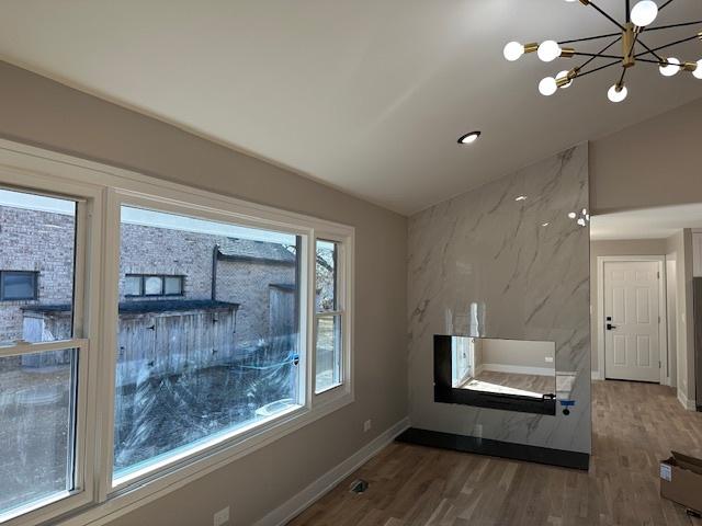 interior space with a notable chandelier, baseboards, and wood finished floors