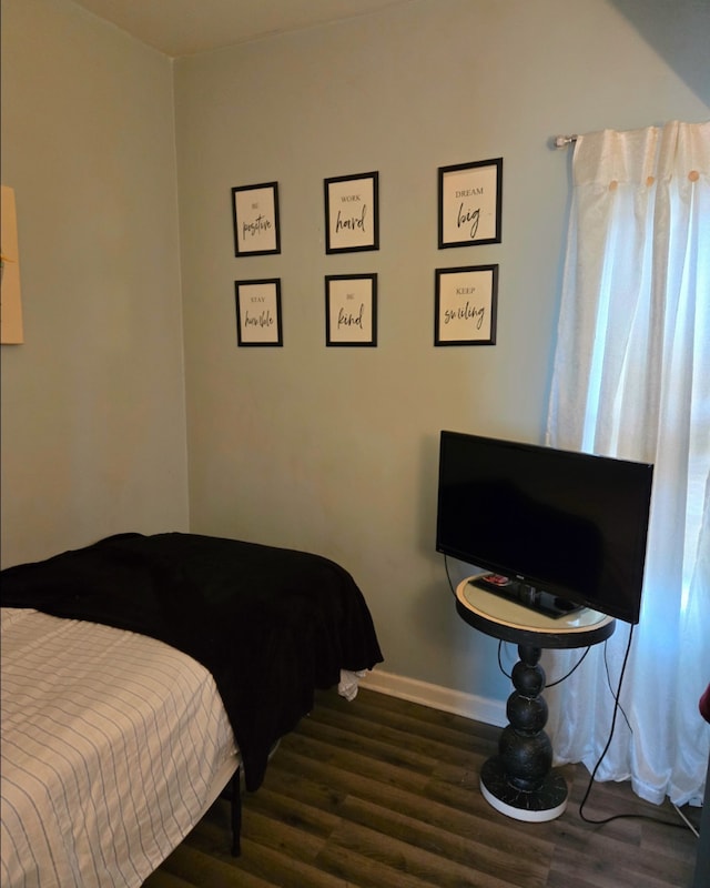 bedroom featuring baseboards and wood finished floors