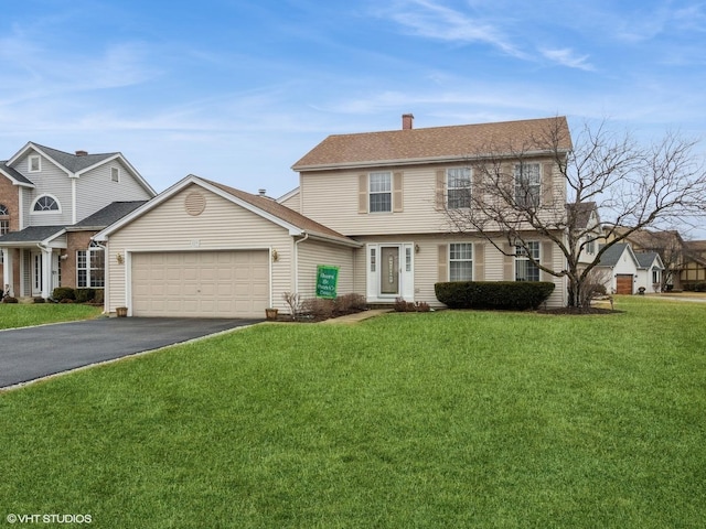 colonial inspired home featuring an attached garage, driveway, a chimney, and a front lawn