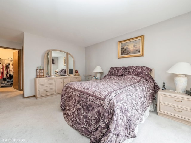 bedroom with light colored carpet and baseboards