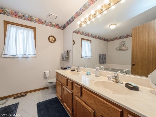 bathroom with a healthy amount of sunlight, visible vents, and a sink