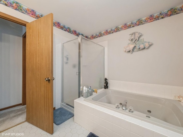 bathroom with a tub with jets, a shower stall, and tile patterned floors