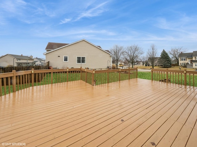 deck featuring a residential view, a lawn, and fence