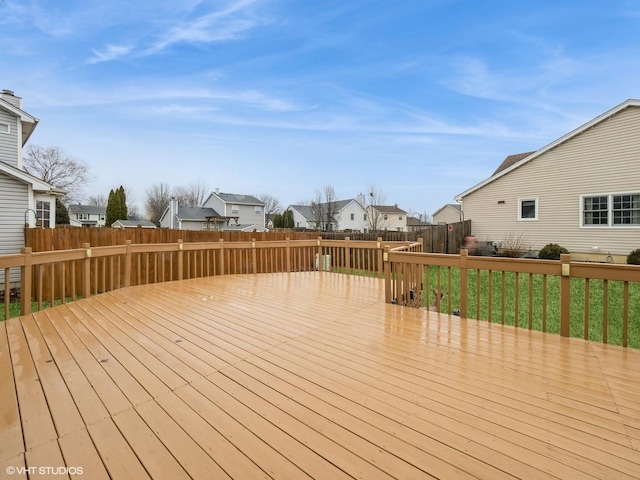 wooden deck featuring a residential view, a fenced backyard, and a lawn