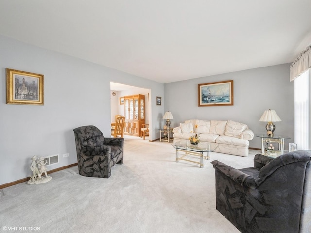 living area featuring carpet, visible vents, and baseboards