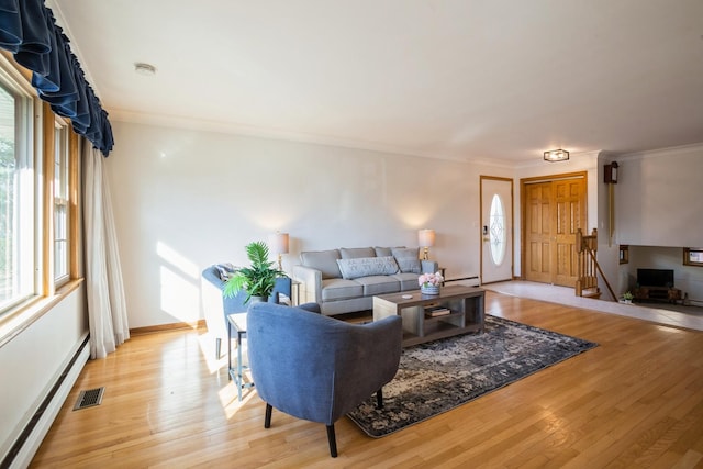 living room featuring visible vents, a healthy amount of sunlight, and light wood-type flooring