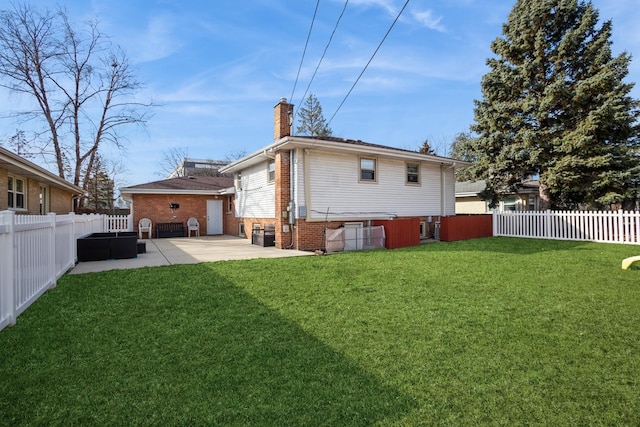 rear view of house with a yard, a chimney, a patio area, and a fenced backyard