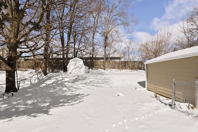 snowy yard featuring fence