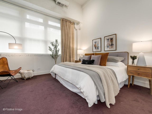 bedroom with dark carpet and baseboards