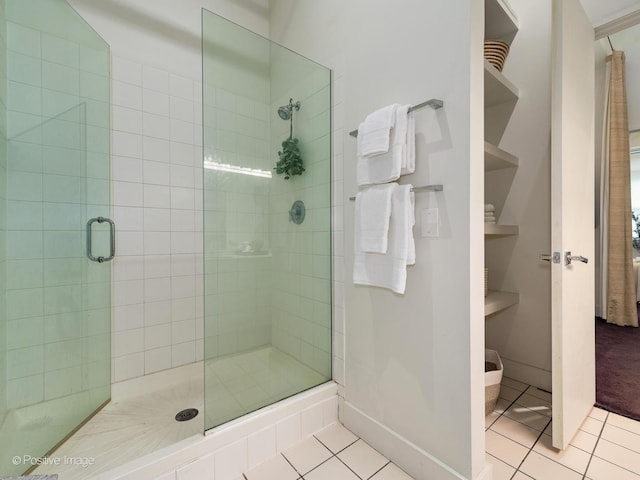 full bathroom with a stall shower, tile patterned flooring, and baseboards