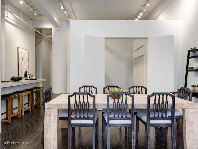 dining area featuring dark wood finished floors and track lighting