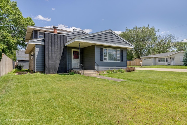 view of front of house featuring a chimney, fence, and a front yard