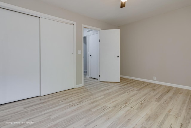 unfurnished bedroom with a closet, wood finished floors, and baseboards