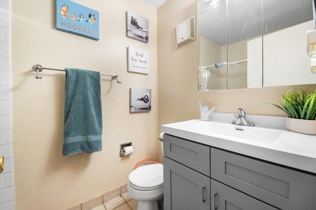 full bath with tile patterned floors, toilet, a stall shower, and vanity