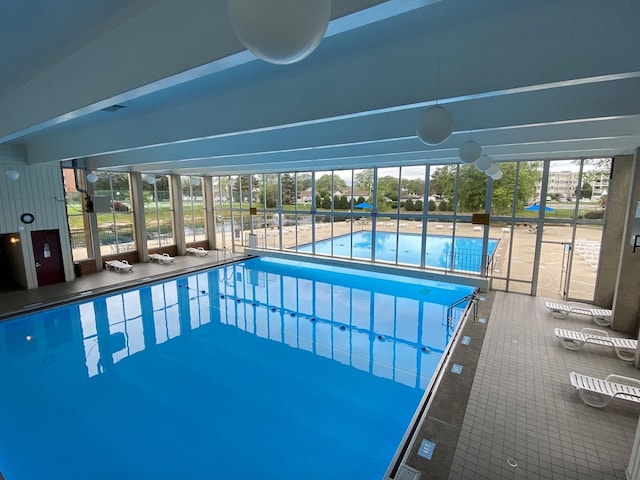 pool with glass enclosure and a patio