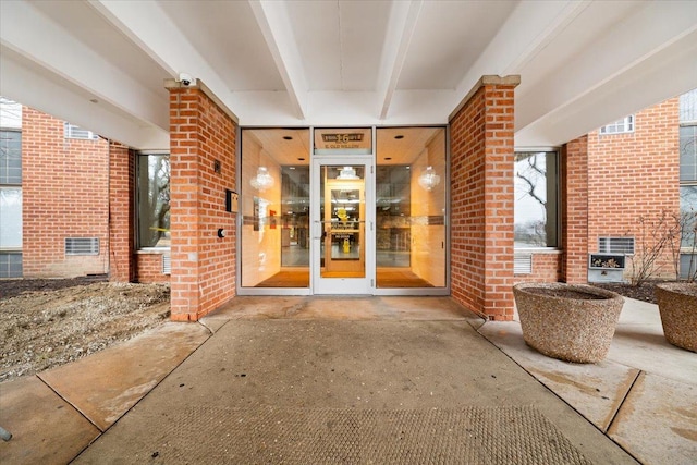 entrance to property featuring brick siding