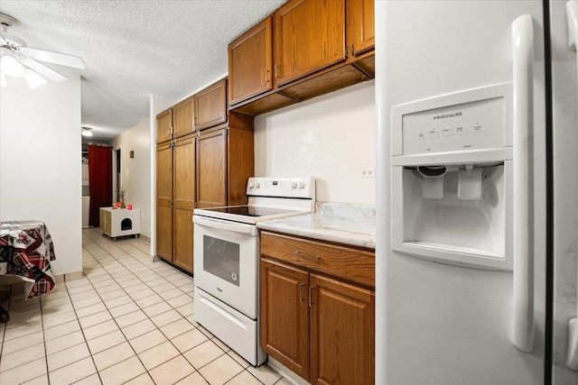 kitchen featuring white appliances, light tile patterned floors, light countertops, and brown cabinets