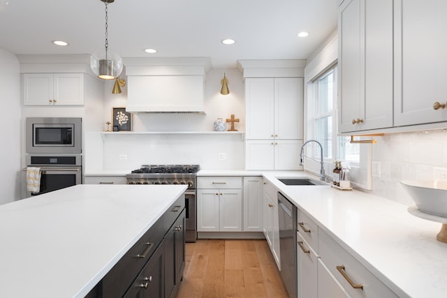 kitchen with a sink, light countertops, appliances with stainless steel finishes, custom exhaust hood, and open shelves