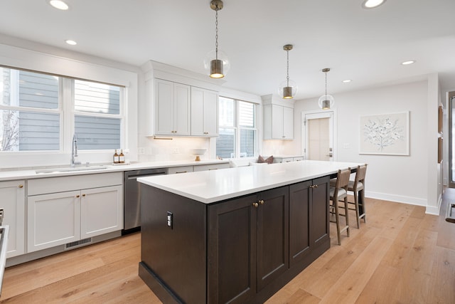 kitchen with a sink, visible vents, white cabinets, and stainless steel dishwasher