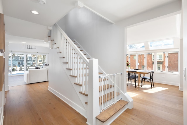 staircase featuring recessed lighting, baseboards, and wood finished floors