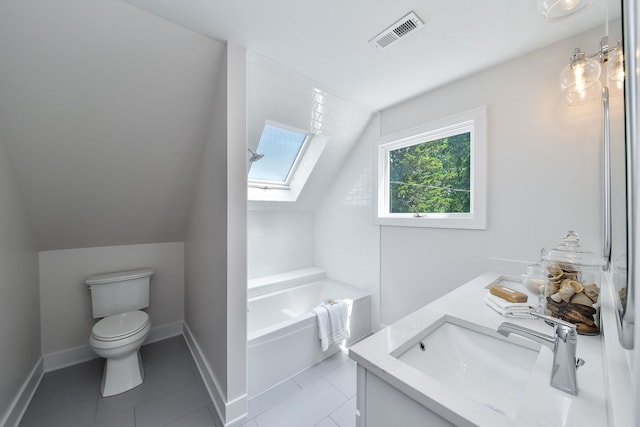 bathroom featuring vaulted ceiling with skylight, visible vents, toilet, a garden tub, and a sink