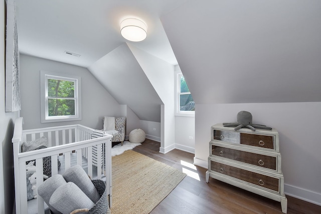 bedroom featuring visible vents, vaulted ceiling, baseboards, and wood finished floors