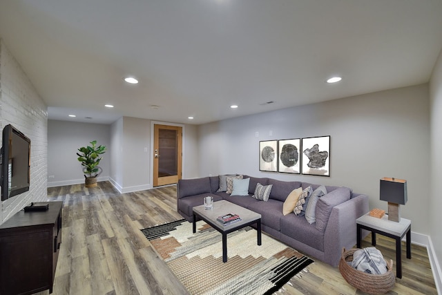 living room featuring baseboards, wood finished floors, and recessed lighting