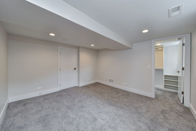 finished basement with carpet, visible vents, and recessed lighting