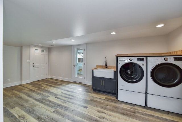 washroom with washer and dryer, a sink, light wood finished floors, and recessed lighting