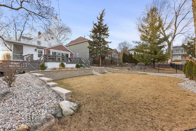 view of yard featuring a sunroom, stairs, fence, and a wooden deck