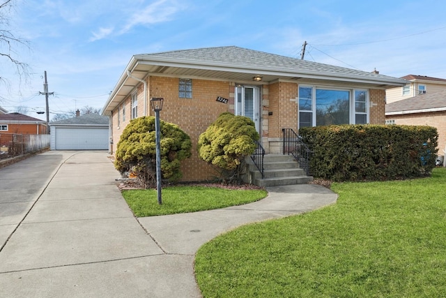 bungalow-style home featuring an outbuilding, brick siding, a detached garage, roof with shingles, and a front lawn