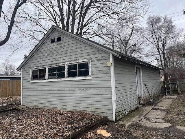 view of side of property with an outbuilding and fence