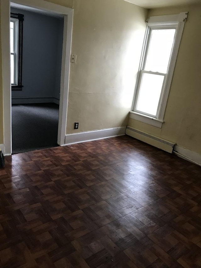 empty room with baseboards and a baseboard heating unit