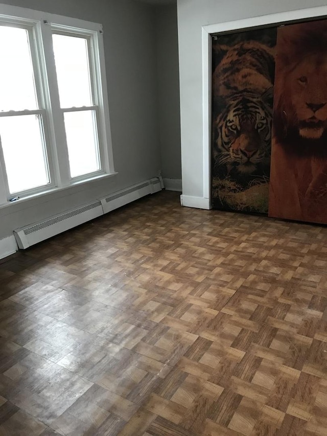 empty room featuring baseboards and a baseboard heating unit